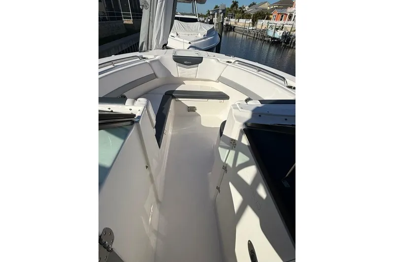 Slide: The Image of 2021 Robalo R317 Dual Console boat interior with seating, docked near waterfront homes. - 7