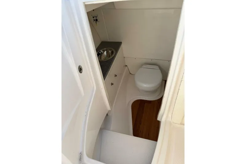 Slide: The Image of 2021 Robalo R317 Dual Console boat interior with toilet and sink. - 9