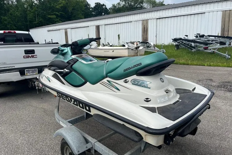 Slide: The Image of 2001 Sea-Doo GTX jet ski on trailer, parked beside a GMC truck. - 2