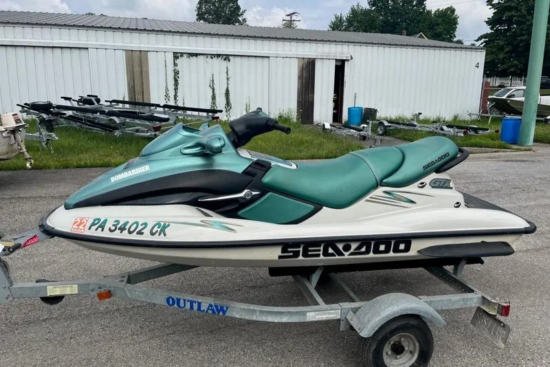 Slide: The Image of 2001 Sea-Doo GTX jet ski on trailer, parked outdoors near storage units. - 3