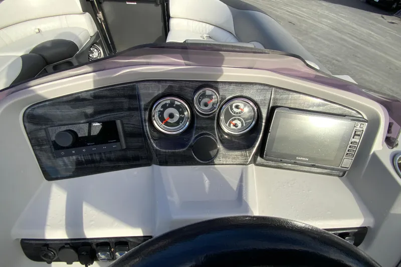 Slide: The Image of Dashboard of 2021 Avalon LSZ Quad Lounger boat with gauges and Garmin display. - 15