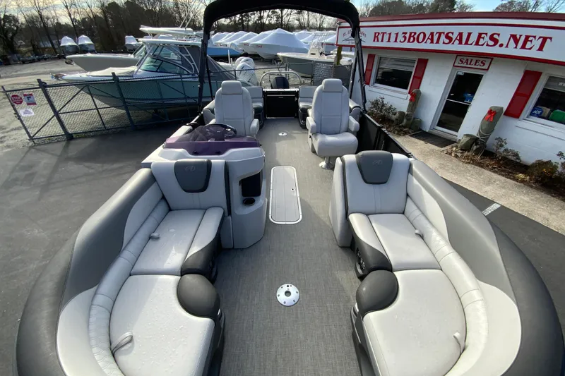 Slide: The Image of 2021 Avalon LSZ Quad Lounger 24' pontoon boat with spacious seating at a boat sales lot. - 24