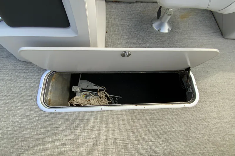 Slide: The Image of Open storage compartment on 2021 Avalon LSZ Quad Lounger boat, containing rope and anchor. - 25