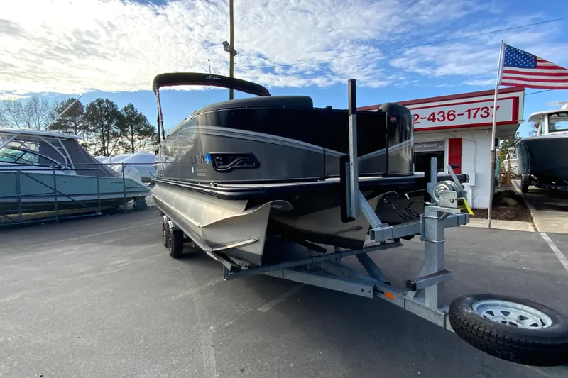 Slide: The Image of 2021 Avalon LSZ Quad Lounger 24' pontoon boat on trailer, dealership background. - 3