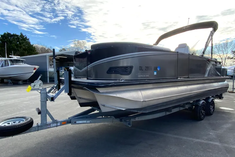 Slide: The Image of 2021 Avalon LSZ Quad Lounger 24' pontoon boat on trailer, parked outdoors. - 5