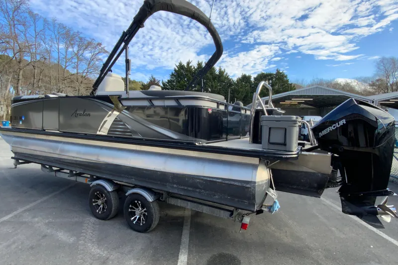 Slide: The Image of 2021 Avalon LSZ Quad Lounger 24' pontoon boat on trailer, featuring Mercury outboard motor. - 7