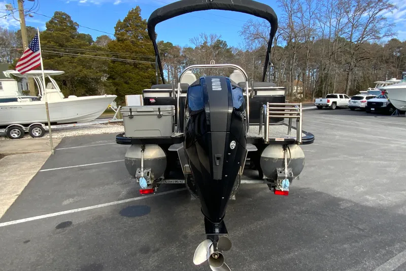 Slide: The Image of 2021 Avalon LSZ Quad Lounger 24' pontoon boat with outboard motor in parking lot. - 9