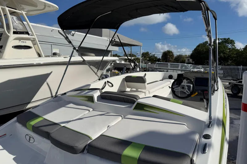 Slide: The Image of 2023 Tahoe T18 boat with sleek design, green accents, and spacious seating under a sunny sky. - 10