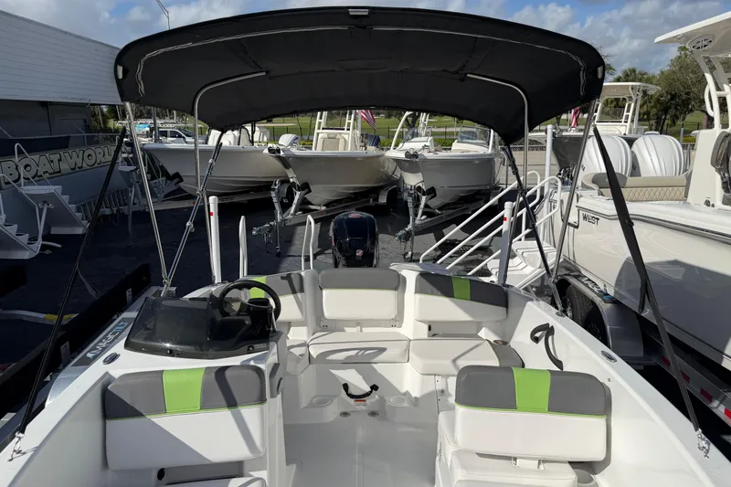 Slide: The Image of 2023 Tahoe T18 boat with canopy, parked among other boats at a dealership. - 11