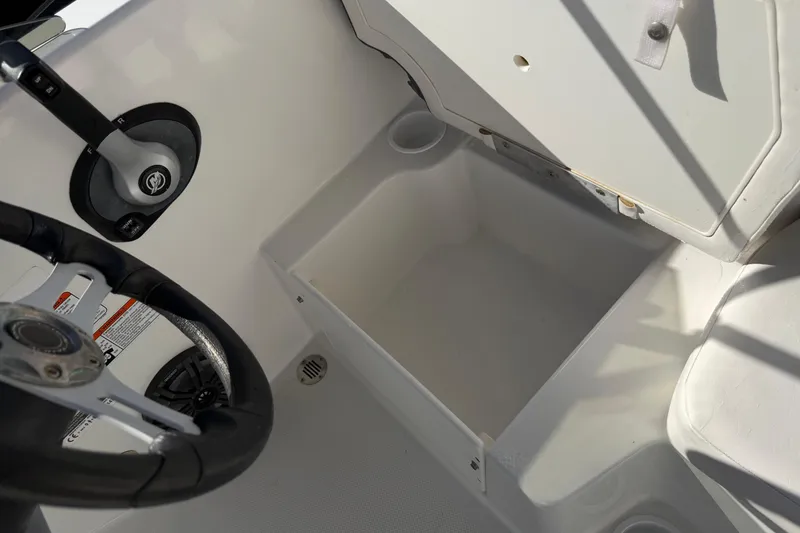 Slide: The Image of 2023 Tahoe T18 boat interior with steering wheel and storage compartment. - 16