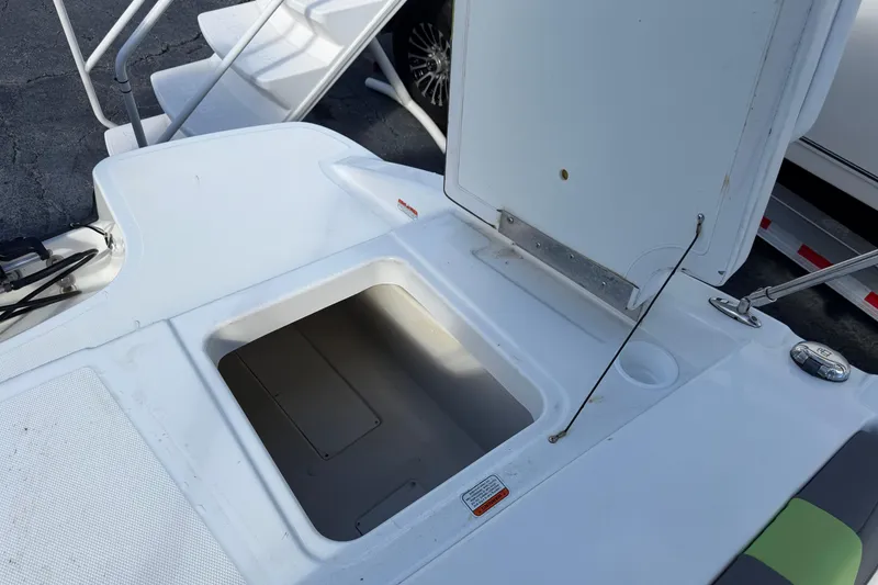 Slide: The Image of 2023 Tahoe T18 boat storage compartment with open hatch, showcasing interior space. - 18