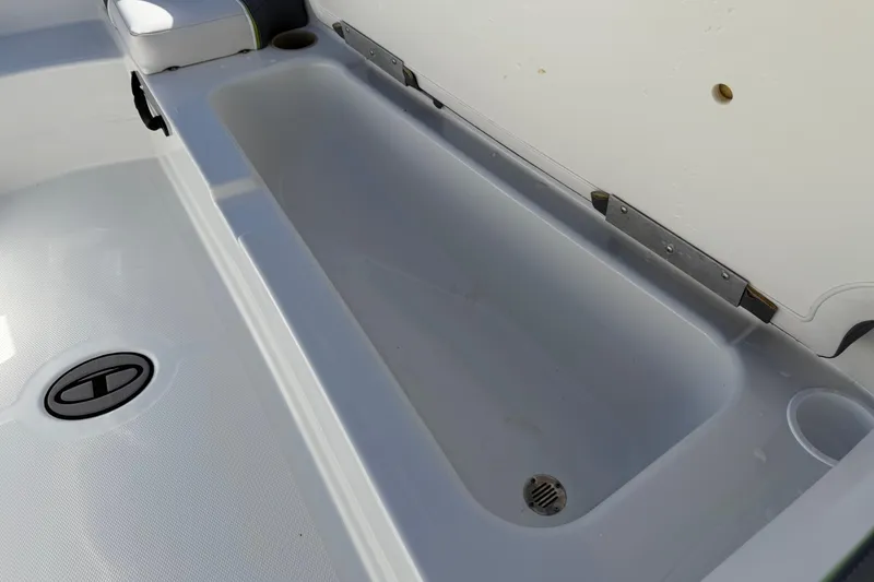 Slide: The Image of 2023 Tahoe T18 boat interior storage compartment with drain and seat cushion. - 22