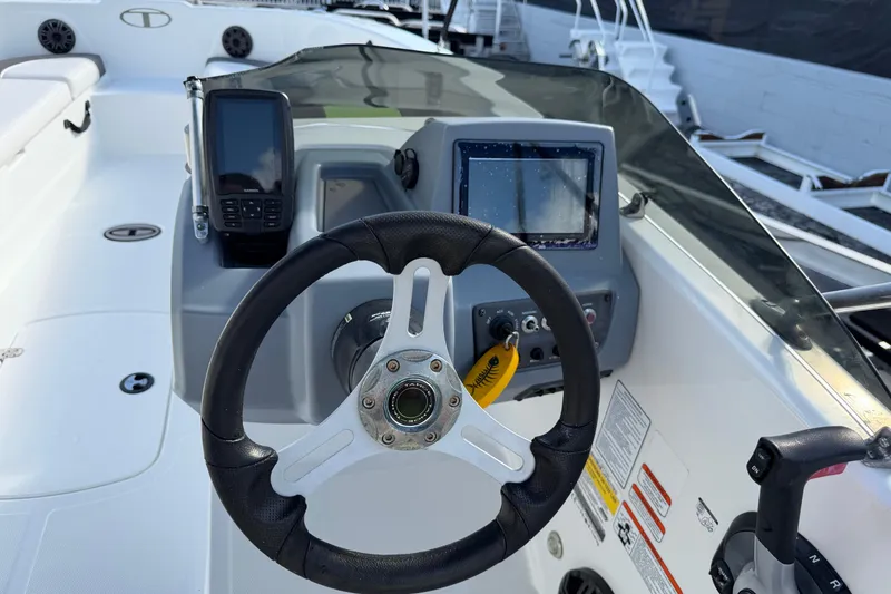 Slide: The Image of 2023 Tahoe T18 boat dashboard with steering wheel and navigation equipment. - 24