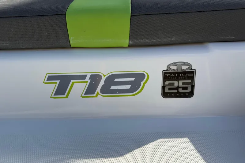 Slide: The Image of 2023 Tahoe T18 boat logo with 25th anniversary badge on white surface. - 30