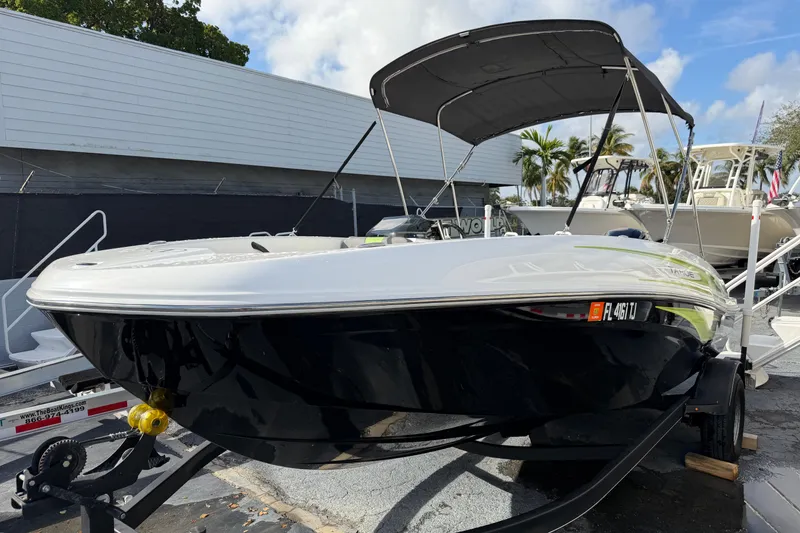 Slide: The Image of 2023 Tahoe T18 boat with canopy on trailer, parked outdoors. - 4