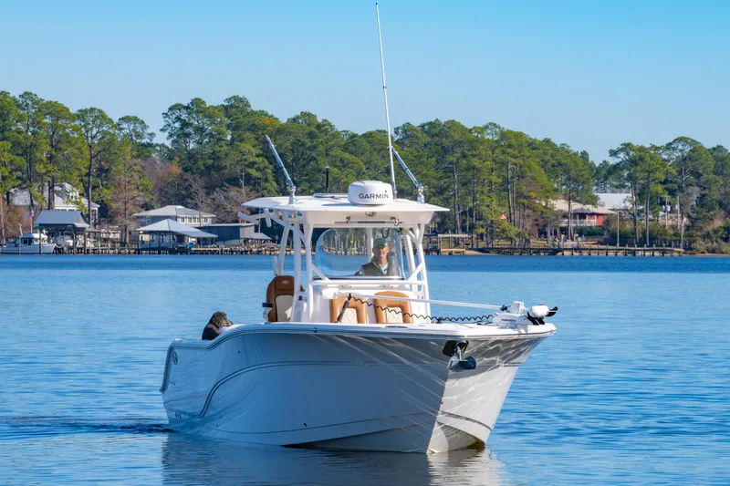 Slide: The Image of 2019 Sea Fox 328 Commander boat cruising on a calm lake with trees in the background. - 11