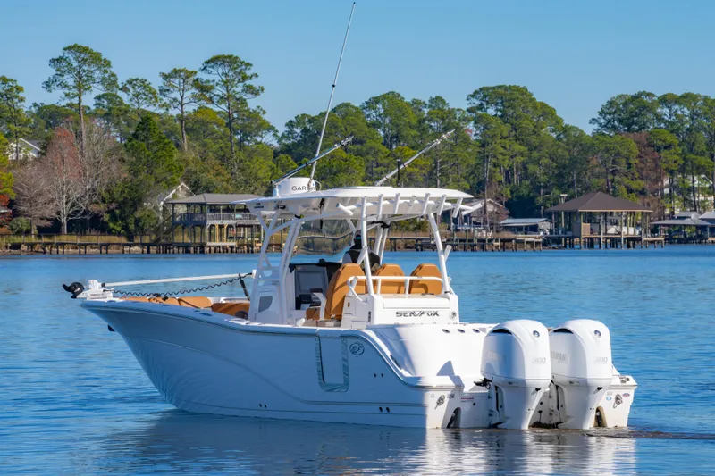Slide: The Image of 2019 Sea Fox 328 Commander boat on calm lake with scenic forest backdrop. - 3