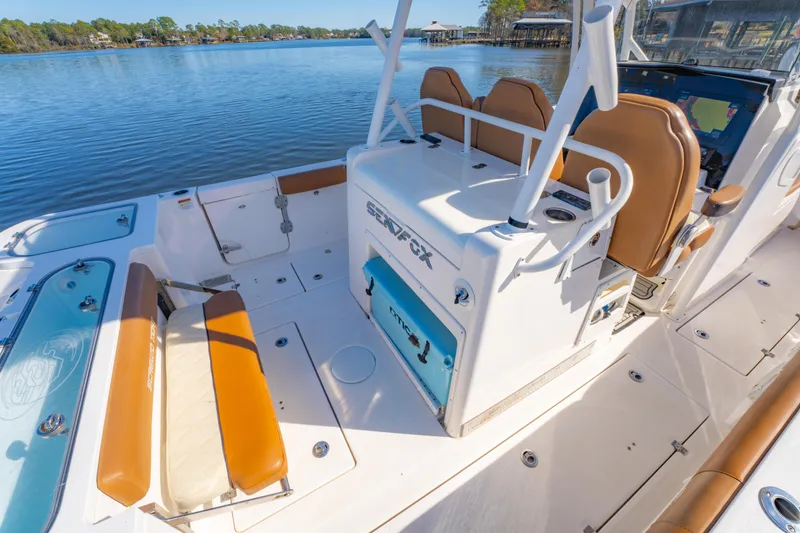 Slide: The Image of 2019 Sea Fox 328 Commander boat interior with seating and storage, docked on a calm lake. - 31