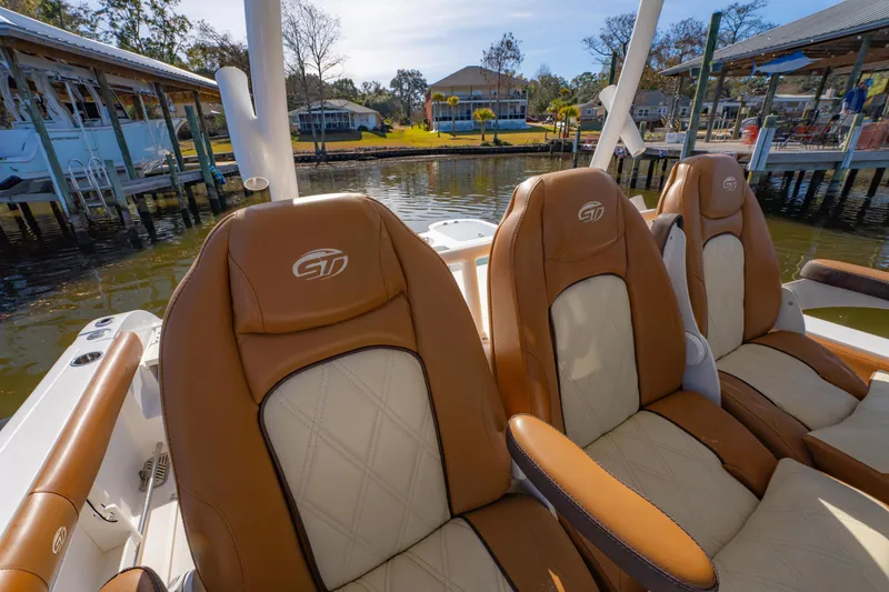 Slide: The Image of 2019 Sea Fox 328 Commander boat seats with brown and cream upholstery by the water. - 45