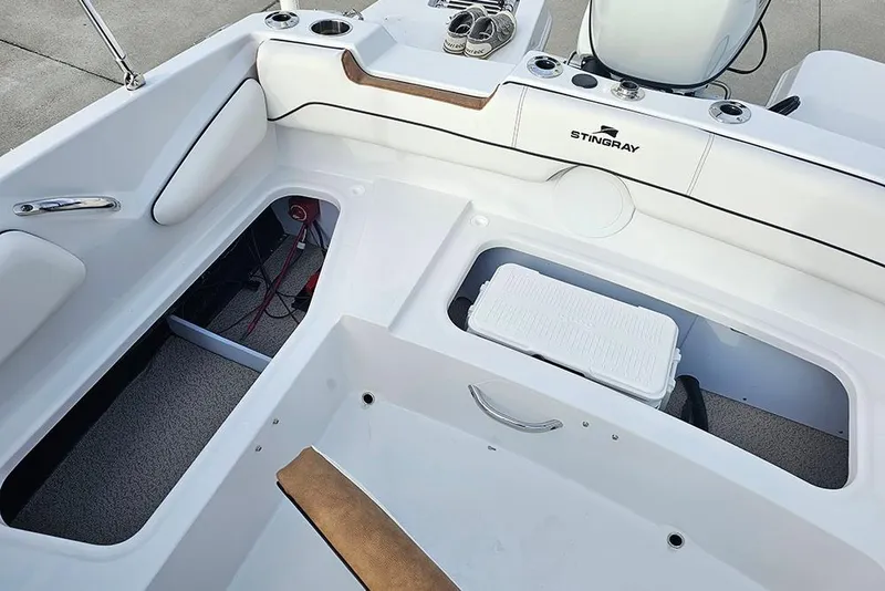 Slide: The Image of 2026 Stingray 191 DC boat interior with white and brown cushioned seating. - 11