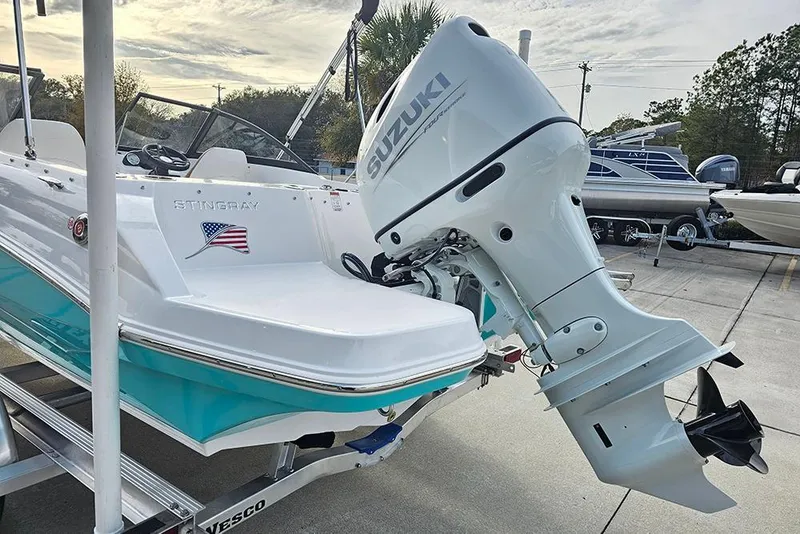 Slide: The Image of 2026 Stingray 191 DC boat on trailer, rear view, with outboard motor and canopy. - 8