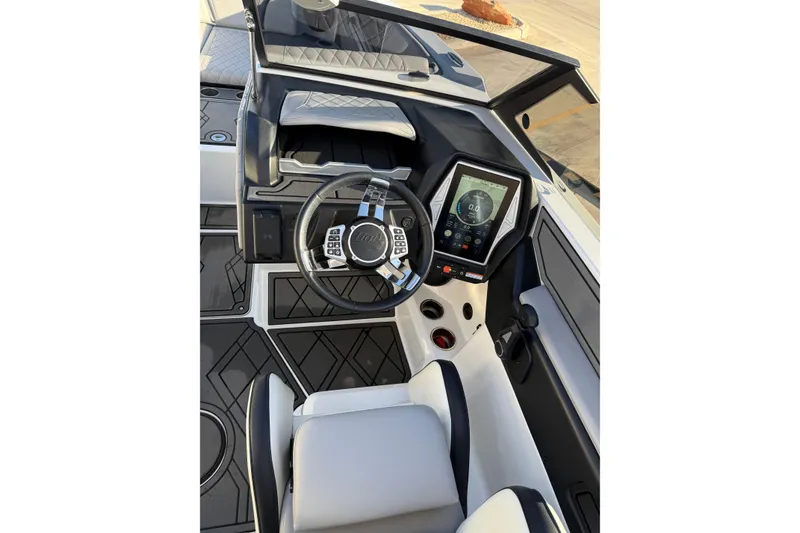 Slide: The Image of 2022 Tigé 24RZX boat cockpit with modern steering wheel and touchscreen display. - 13