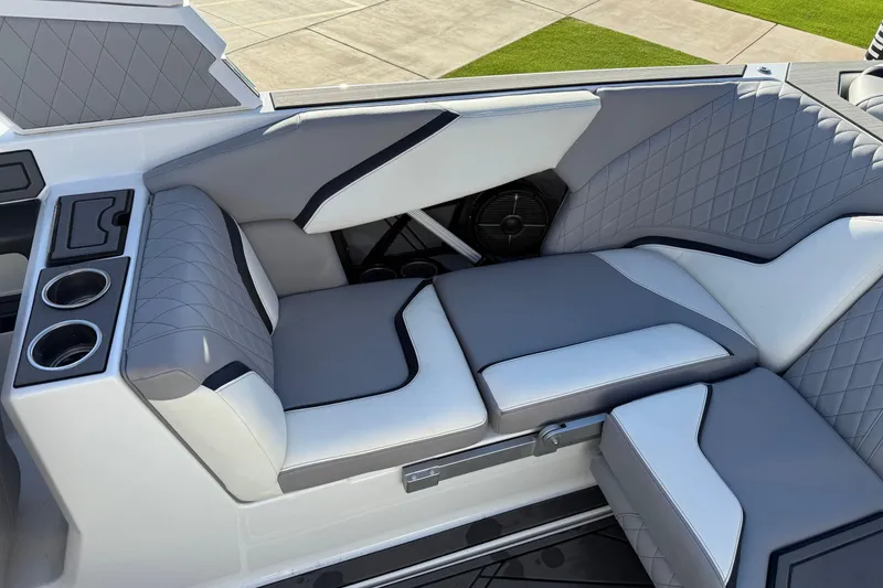 Slide: The Image of 2022 Tigé 24RZX boat interior with gray and white cushioned seating and cup holders. - 17