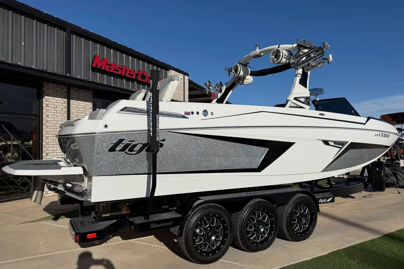 Slide: The Image of 2022 Tigé 24RZX boat on trailer outside dealership, showcasing sleek design and modern features. - 3