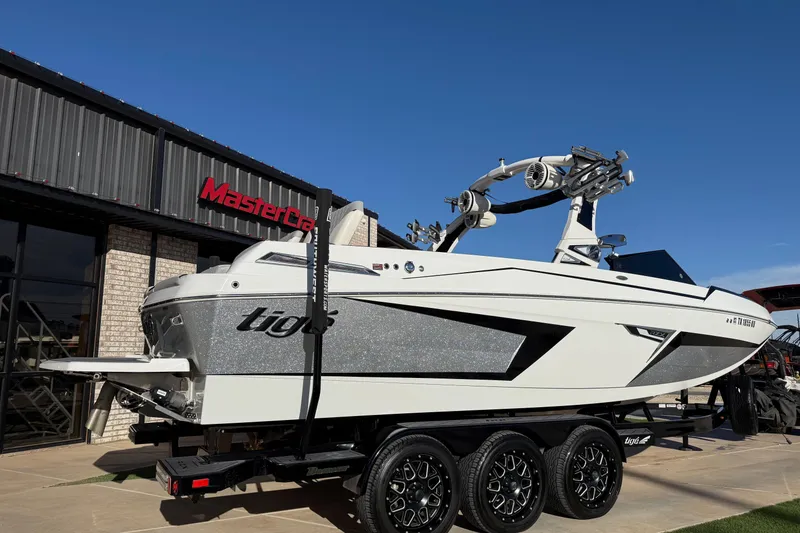 Slide: The Image of 2022 Tigé 24RZX boat on trailer outside MasterCraft dealership. - 4