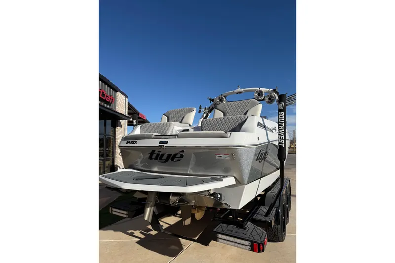 Slide: The Image of 2022 Tigé 24RZX boat on trailer, rear view, under clear blue sky. - 5