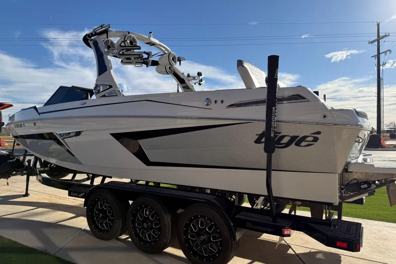 Slide: The Image of 2022 Tigé 24RZX boat on trailer, sleek design, sunny day background. - 8