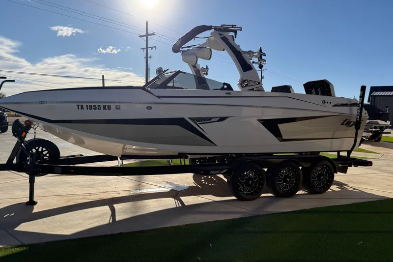 Slide: The Image of 2022 Tigé 24RZX boat on trailer, parked outdoors under clear sky. - 9