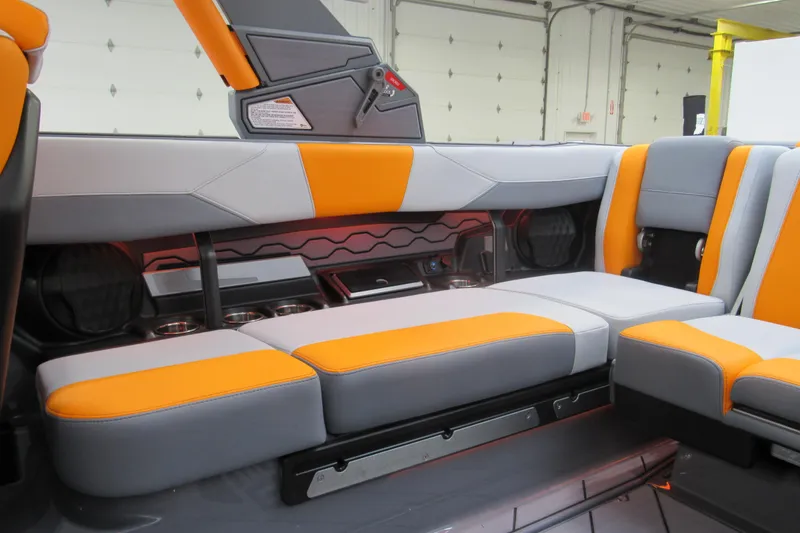 Slide: The Image of 2026 Malibu Wakesetter 23 LSV interior with orange and gray seating, cup holders, and modern design. - 7