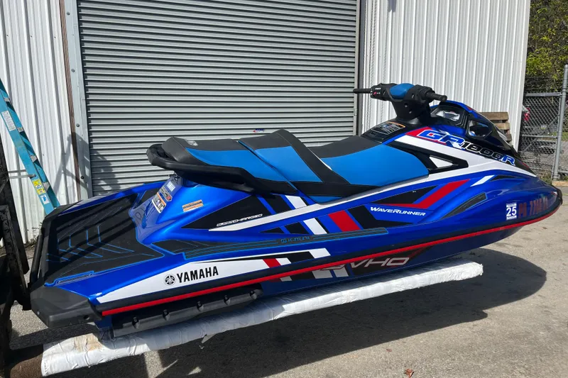 Slide: The Image of 2020 Yamaha WaveRunner GP1800R SVHO in blue, parked outdoors near a metal building. - 3