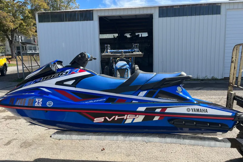 Slide: The Image of 2020 Yamaha WaveRunner GP1800R SVHO in blue, parked outdoors near a garage. - 4
