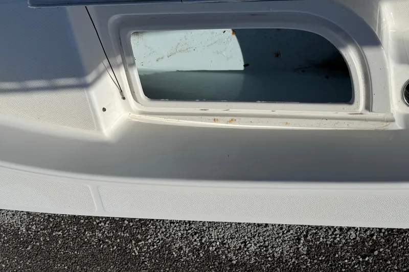 Slide: The Image of 2013 Sundance DX22 boat compartment with visible wear and dirt. - 12