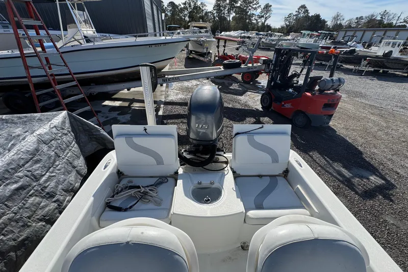 Slide: The Image of 2013 Sundance DX22 boat with 115 HP motor in a marina storage area. - 14
