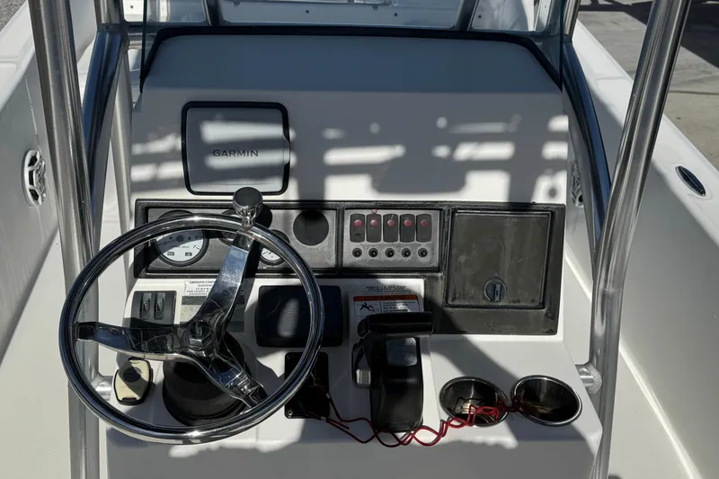 Slide: The Image of 2013 Sundance DX22 boat dashboard with steering wheel and Garmin navigation system. - 4