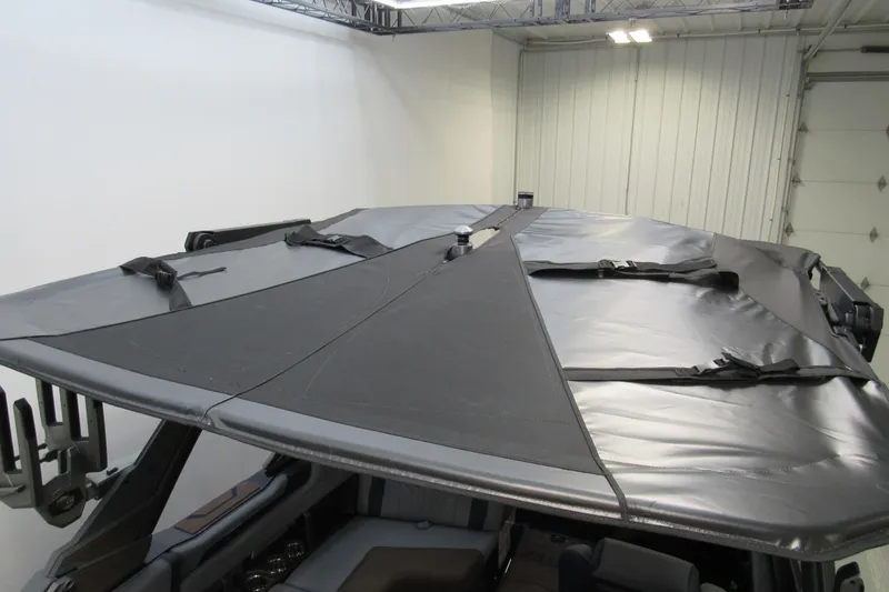 Slide: The Image of 2026 Malibu Wakesetter 25 LSV boat with protective cover in a garage setting. - 19