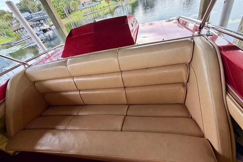 Slide: The Image of 1981 Glastron/Carlson C-512 boat interior with tan leather seating by a lakeside. - 11