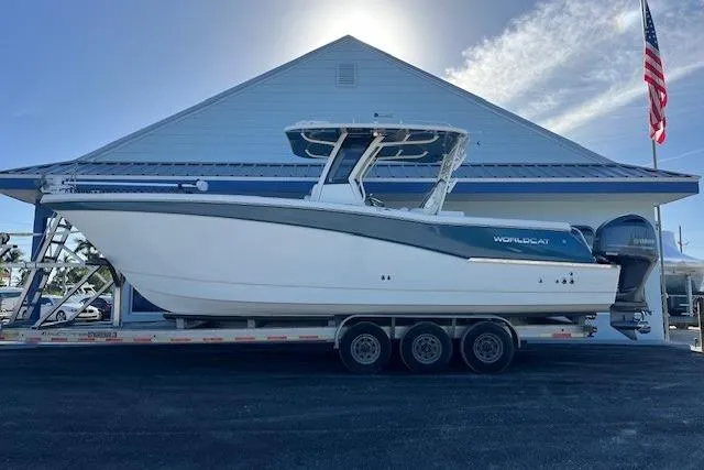 The Image of 2020 World Cat 280 CC-X boat on trailer, parked outside a building with an American flag. - 1