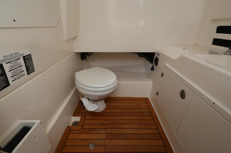 Slide: The Image of Interior of a boat cabin with a toilet and wooden floor. - 32
