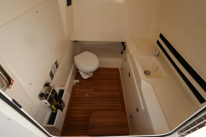 Slide: The Image of Interior of the 2026 Boston Whaler 330 Outrage featuring a toilet and sink. - 31