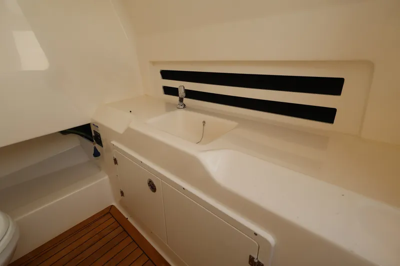 Slide: The Image of Interior of the 2026 Boston Whaler 330 Outrage with a sink and storage space. - 34