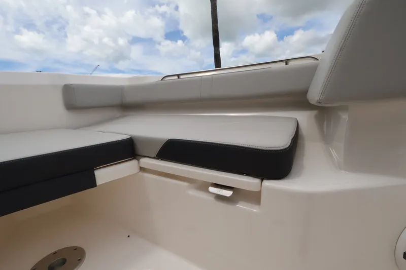 Slide: The Image of The 2026 Boston Whaler 330 Outrage features a cushioned seating area under a cloudy sky. - 43