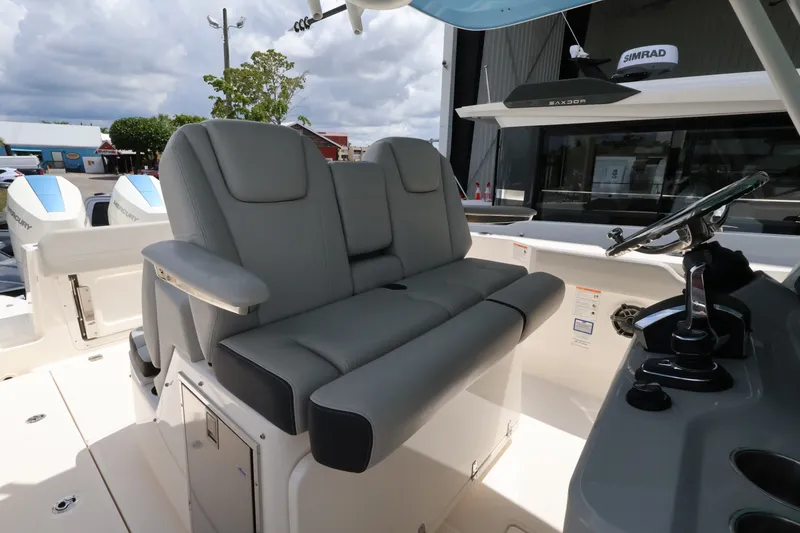 Slide: The Image of The image shows the helm of a Boston Whaler 330 Outrage with gray seating and modern electronics. - 20