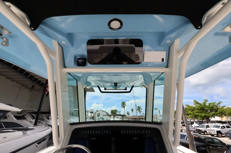 Slide: The Image of The image shows the cockpit of a 2026 Boston Whaler 330 Outrage with a blue roof and white supports. - 23