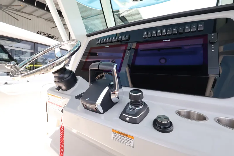Slide: The Image of The image shows the helm of a Boston Whaler 330 Outrage with modern navigation systems. - 24