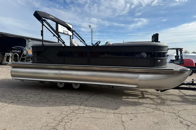 Slide: The Image of 2026 Bentley Pontoons Bolt 223 pontoon boat with Suzuki engine, parked outdoors. - 2