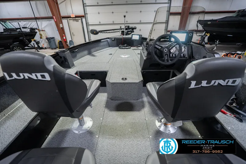 Slide: The Image of 2026 Lund 1700 Explorer SS boat interior with dual seats and steering console in a showroom. - 15